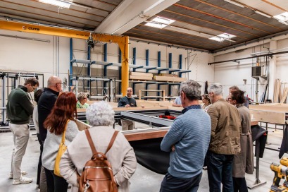 Mensen krijgen rondleiding in houtskeletbouwfabriek