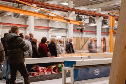 Groep mensen tijdens rondleiding in houtskeletbouwfabriek