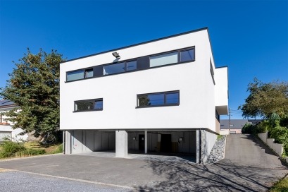 Dewaele Woningbouw - Achteraanzicht hoek moderne dokterspraktijk met plat dak