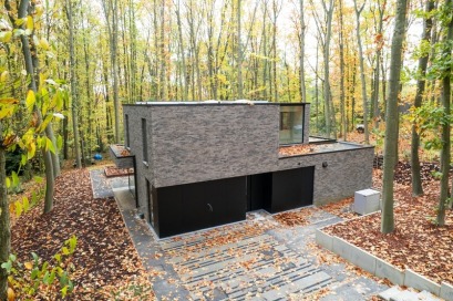 Maison moderne à ossature bois de Dewaele dans un cadre boisé.