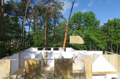 Construction d’une maison à ossature bois avec murs préfabriqués.