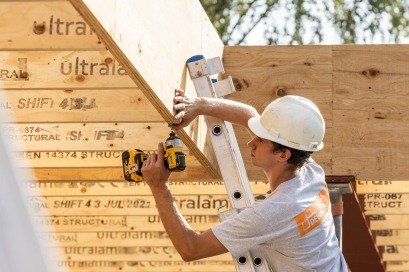 Monteur Dewaele plaçant une poutre LVL sur chantier ossature bois.