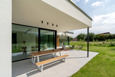 Overdekt terras van een moderne houtskeletbouwwoning met plat dak