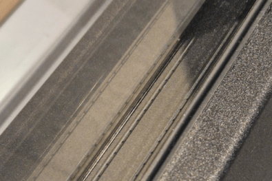 Close-up van zwarte warm edge afstandshouders in venster