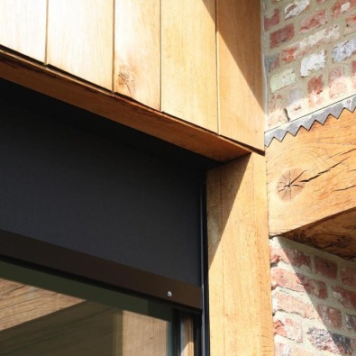 Detail houten gevel met geïntegreerde zonwering.