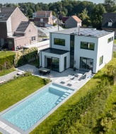 Moderne houtskeletwoning met zwembad en zonnepanelen.