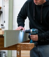 Schrijnwerker van Dewaele in het atelier met een Makita schroefmachine.