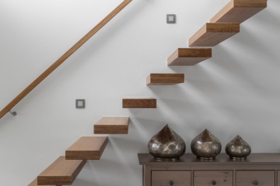 Moderne zwevende houten trap in interieur.