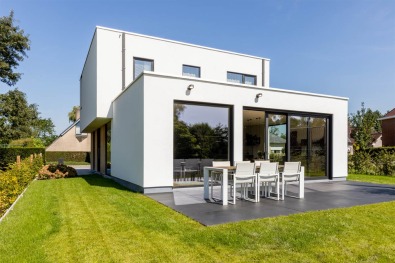 Villa blanche moderne avec terrasse de jardin.