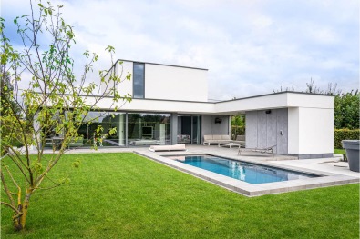 Moderne woning met strakke gevels en zwembad.