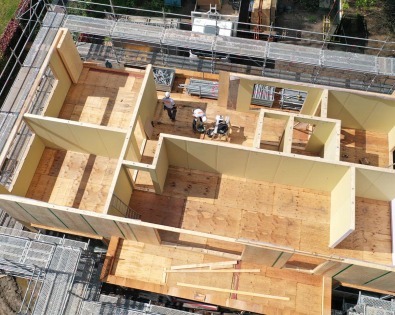 Houten ruwbouw van woning in aanbouw met zicht op binnenmuren.