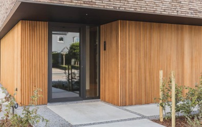 Ingang van de kijkwoning in De Pinte met verticale houten gevelbekleding.