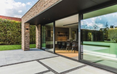 Terras met schuifraam in kijkwoning in houtskeletbouw in De Pinte.