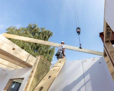 Plaatsing van houten balk in houtskeletbouw.