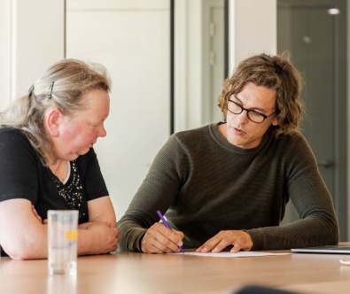 Client et collaborateur discutent d’un dossier de construction.