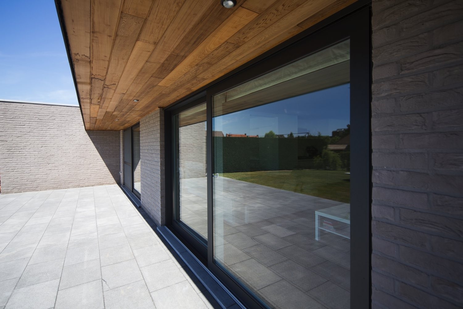 Houtskeletbouw in moderne stijl, halfopen bebouwing, grijze baksteen en HPL-platen van Trespa